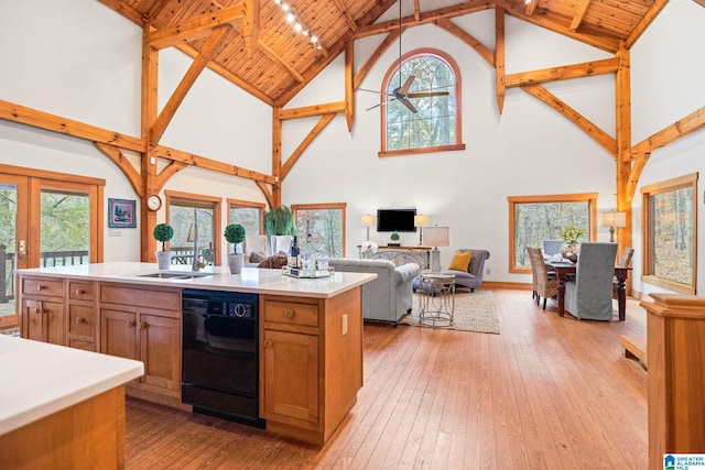 kitchen featuring beamed ceiling, dishwasher, wood ceiling, high vaulted ceiling, and a kitchen island with sink