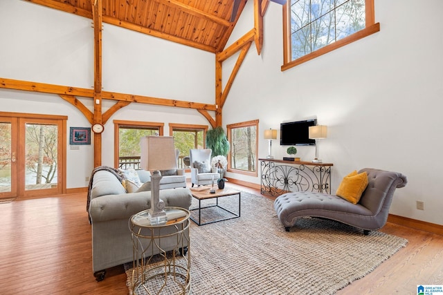 living room featuring wooden ceiling, french doors, light wood-type flooring, high vaulted ceiling, and beam ceiling