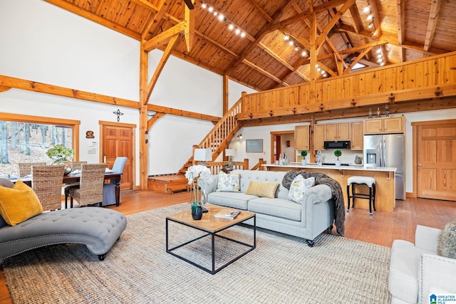 living room featuring light wood-type flooring, high vaulted ceiling, beam ceiling, and wood ceiling