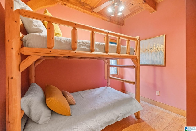 bedroom with ceiling fan, light wood-type flooring, beamed ceiling, and wood ceiling