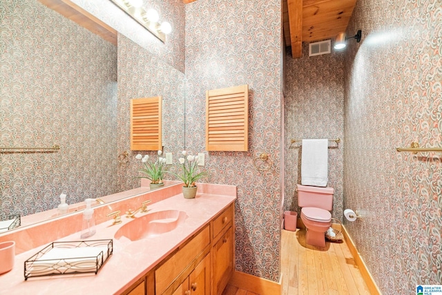 bathroom with toilet, hardwood / wood-style flooring, and vanity