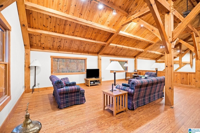 living room featuring a healthy amount of sunlight, track lighting, light hardwood / wood-style flooring, beam ceiling, and wooden ceiling