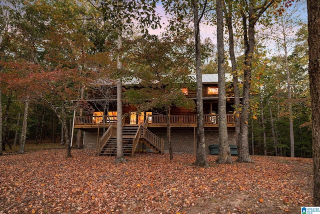 back house at dusk with a wooden deck