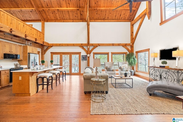 living room with high vaulted ceiling, ceiling fan, wooden ceiling, and light hardwood / wood-style flooring