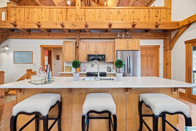 kitchen featuring stainless steel fridge with ice dispenser, a kitchen island with sink, wood-type flooring, and wood ceiling