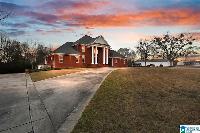 neoclassical home featuring a yard