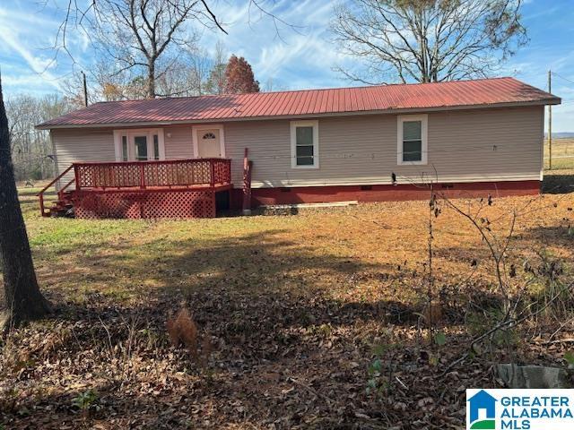 rear view of property featuring a yard and a wooden deck