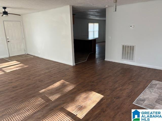 spare room with ceiling fan, dark hardwood / wood-style floors, and a textured ceiling