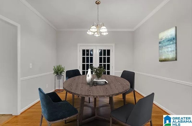 dining area featuring ornamental molding, a notable chandelier, and hardwood / wood-style flooring