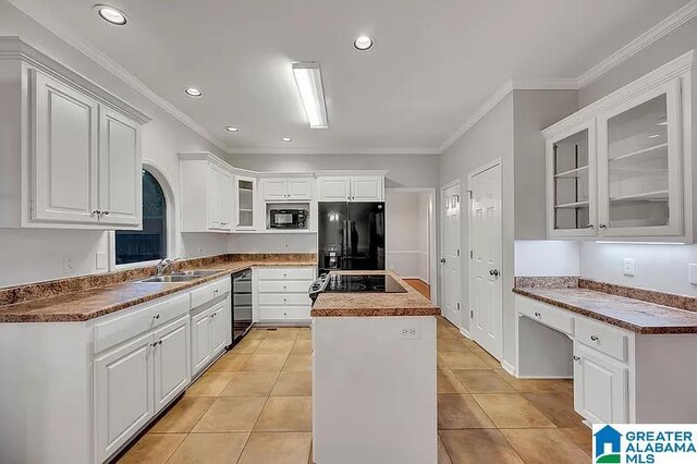 kitchen with crown molding, white cabinetry, a center island, and black appliances