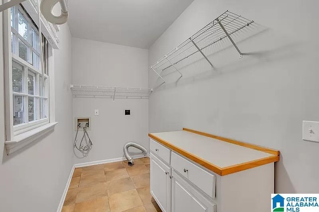 laundry room featuring hookup for an electric dryer, cabinets, light tile patterned floors, and hookup for a washing machine