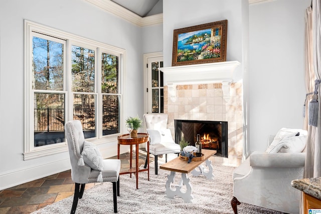 sitting room with a tile fireplace and lofted ceiling