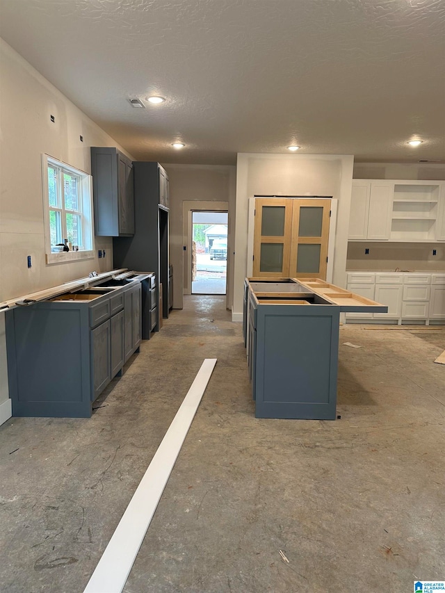 kitchen featuring gray cabinetry, a wealth of natural light, and a textured ceiling