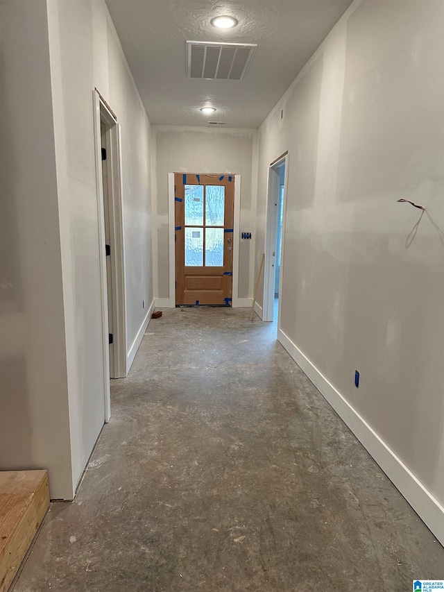 hallway with concrete floors and a textured ceiling