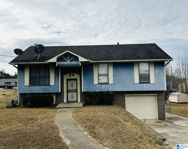 raised ranch featuring a garage and a front lawn