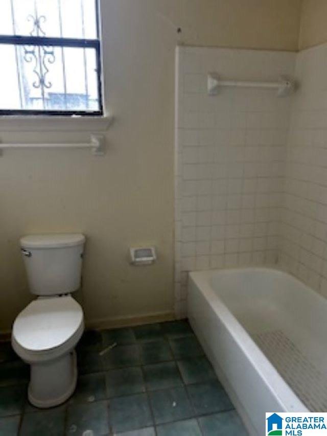 bathroom with tile patterned flooring, shower / bath combination, and toilet