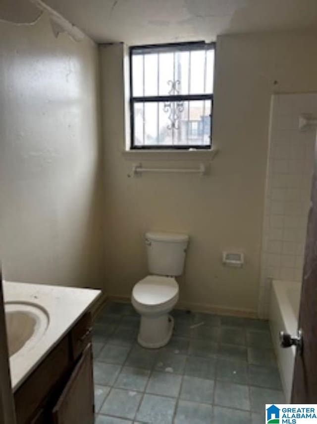 full bathroom with washtub / shower combination, tile patterned floors, toilet, and vanity