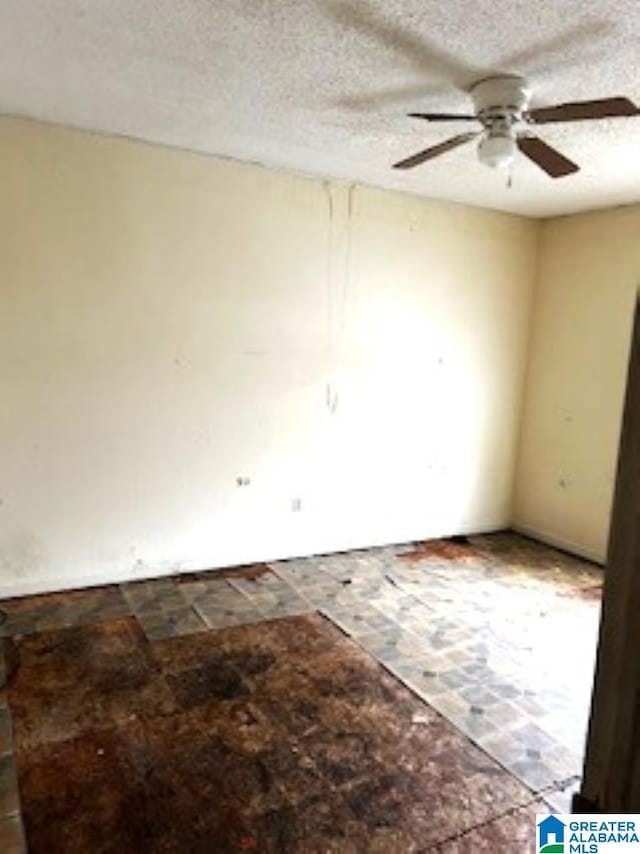 spare room with a textured ceiling and ceiling fan