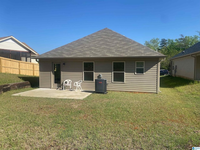 back of house featuring a yard, fence, a patio, central air condition unit, and roof with shingles