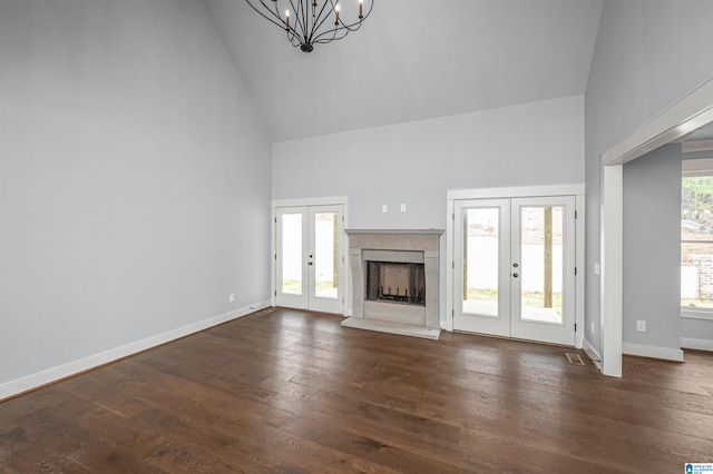 unfurnished living room with a fireplace, french doors, dark hardwood / wood-style flooring, and a wealth of natural light