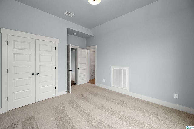 unfurnished bedroom with a closet and light colored carpet