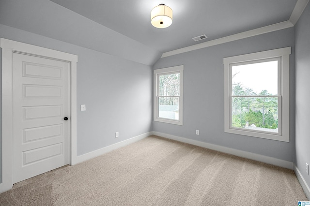 empty room featuring lofted ceiling and light carpet