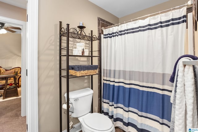 bathroom featuring ceiling fan, a shower with shower curtain, and toilet