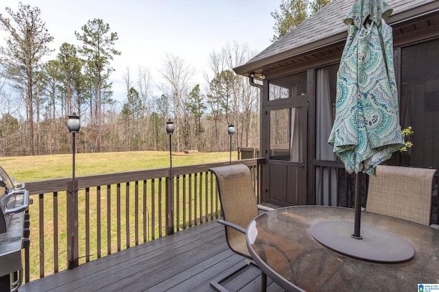 deck featuring a sunroom and a yard