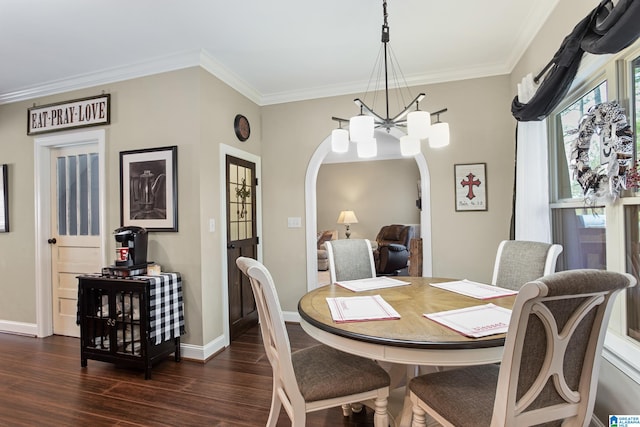 dining space featuring dark hardwood / wood-style floors, an inviting chandelier, and ornamental molding