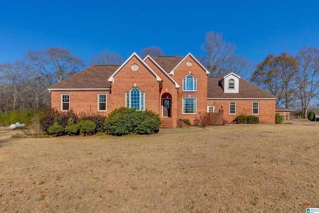 view of front of property featuring brick siding and a front lawn