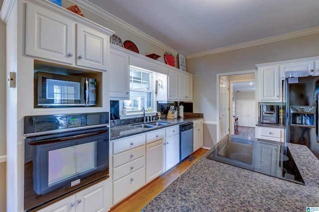 kitchen with crown molding, sink, white cabinets, and black appliances