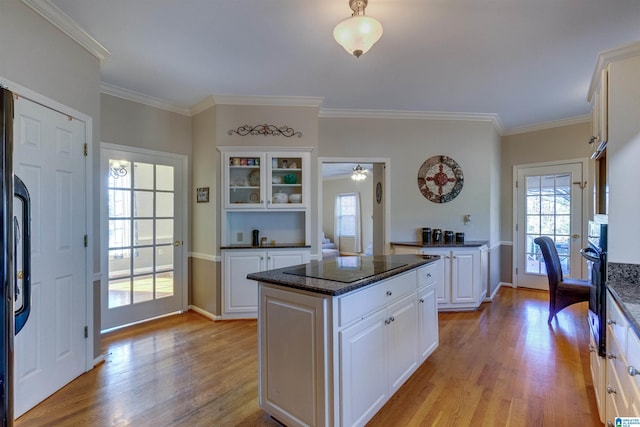 kitchen featuring a center island, light hardwood / wood-style flooring, white cabinetry, and ornamental molding