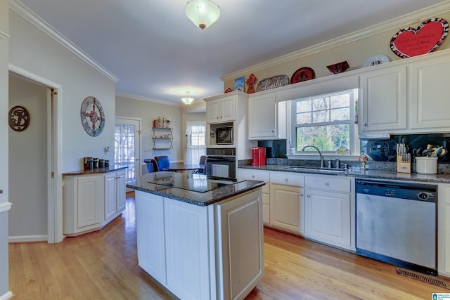 kitchen featuring white cabinetry, a center island, sink, black appliances, and ornamental molding