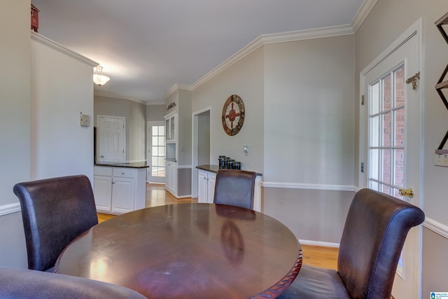 dining area featuring light hardwood / wood-style floors and ornamental molding