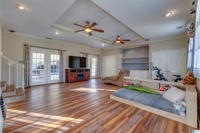 living room featuring hardwood / wood-style floors, french doors, crown molding, and ceiling fan