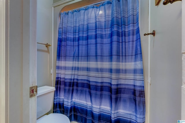 bathroom with a shower with curtain and toilet