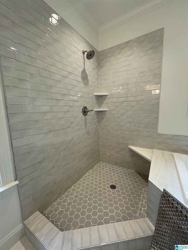 bathroom with crown molding and tiled shower