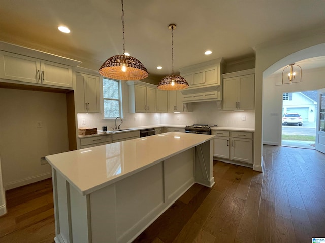 kitchen featuring decorative light fixtures, a center island, white cabinets, and dark wood-type flooring