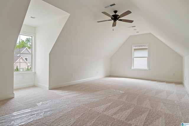 additional living space featuring light carpet, vaulted ceiling, and ceiling fan