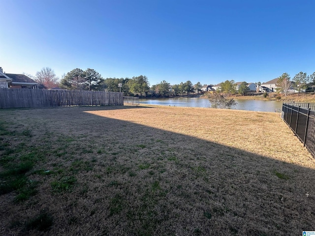 view of yard with a water view and fence