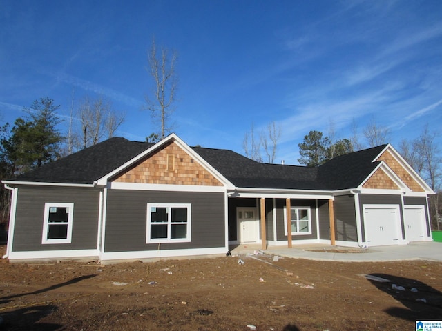 ranch-style home featuring a porch and a garage