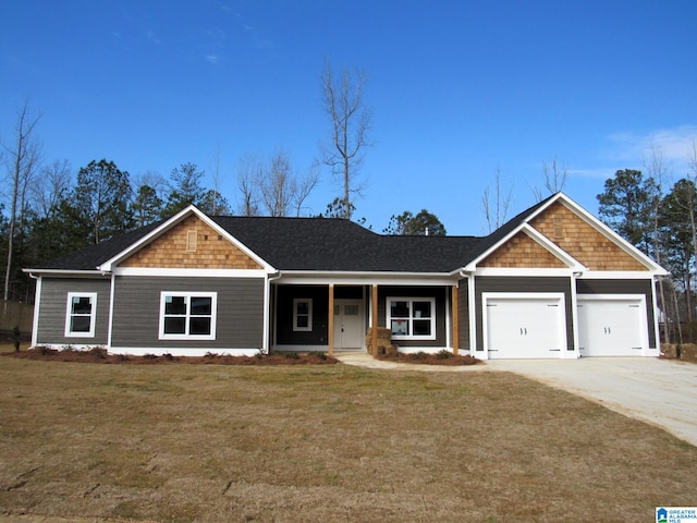 view of front of property with a porch, a front yard, and a garage