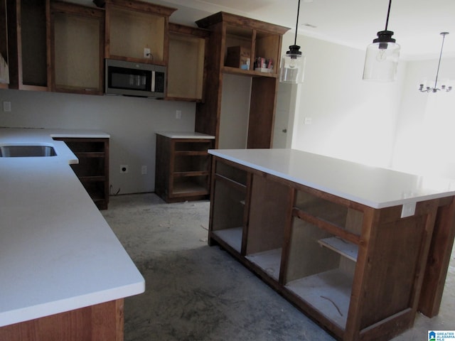 kitchen with sink, a kitchen island, and pendant lighting