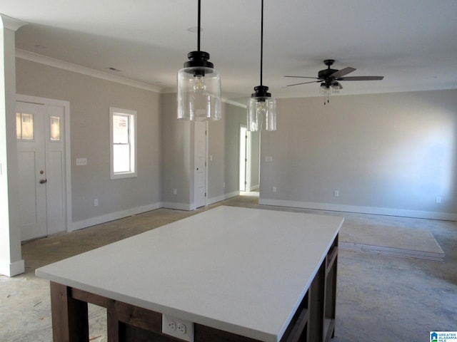 kitchen with ceiling fan, a kitchen island, hanging light fixtures, and crown molding