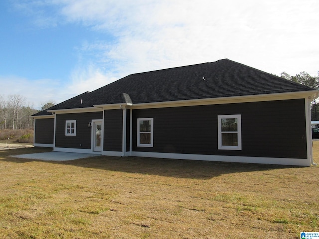 rear view of property with a yard and a patio area