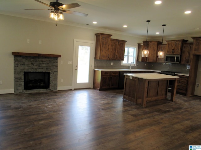 kitchen featuring pendant lighting, dark wood-type flooring, a kitchen island, ceiling fan, and backsplash