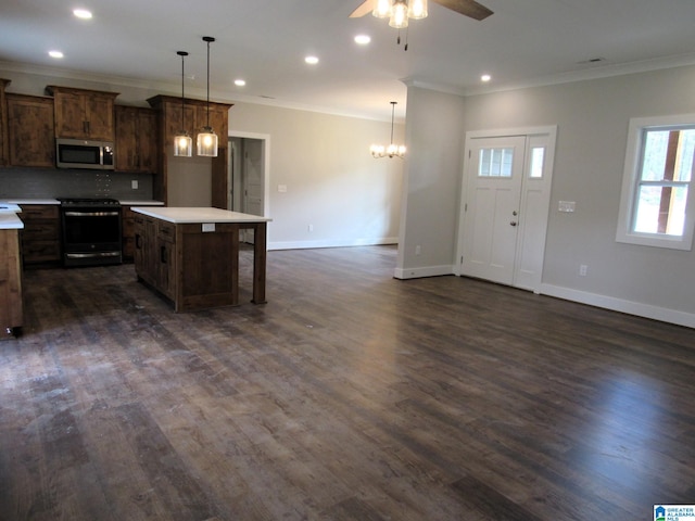 kitchen with pendant lighting, a center island, range with electric cooktop, ceiling fan with notable chandelier, and dark hardwood / wood-style floors