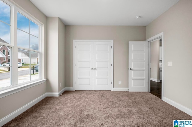 unfurnished bedroom with carpet floors and a closet