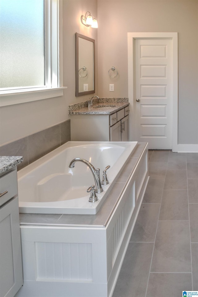 bathroom with tile patterned floors, vanity, and a washtub