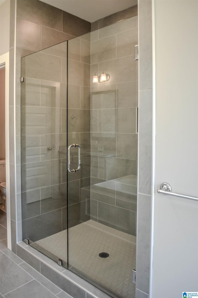 bathroom featuring walk in shower and tile patterned flooring